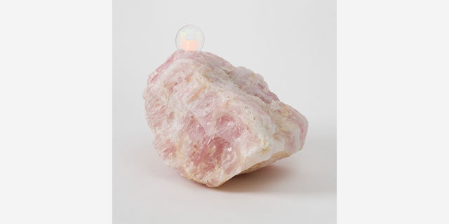 A large pink quartz with a disc-shaped memory crystal embedded in its top